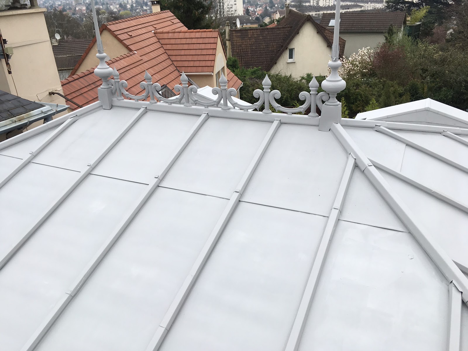 Toiture en zinc avec ornements de faîtage travaillés.