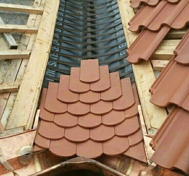 Détail de noue avec découpes précises de tuiles plates.