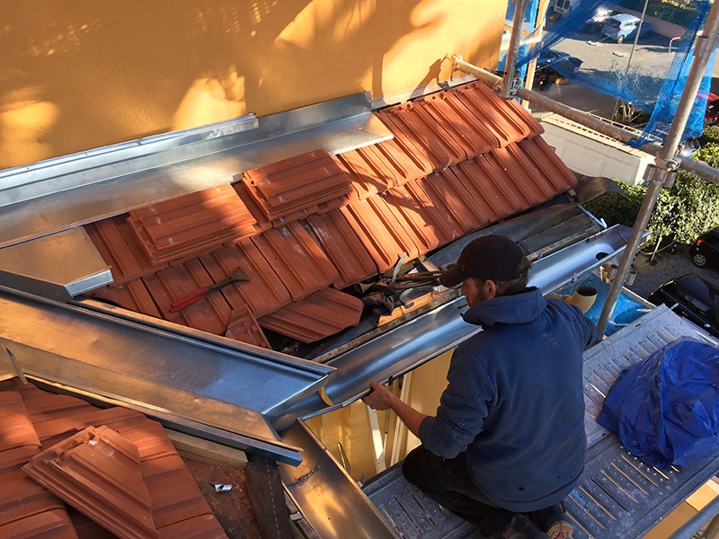 Travaux de zinguerie et pose de tuiles en terre cuite.